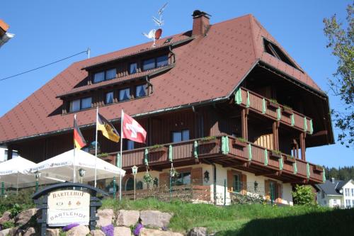 un grande edificio con bandiere di fronte ad esso di Landhotel Bartlehof a Schluchsee