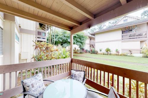 a patio with a table and chairs on a balcony at Sandpiper #116b in Princeville