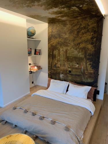 a bedroom with a large bed with a painting on the wall at Margaretha's Room in Mechelen