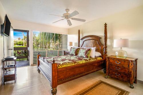 a bedroom with a bed and a ceiling fan at SandPiper #116a in Princeville