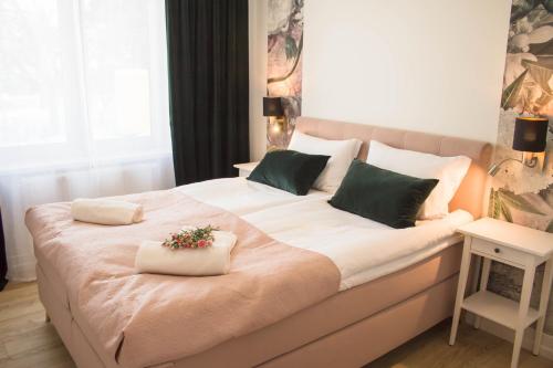 a bedroom with a large white bed with green pillows at Apartamenty Nad Żylicą przy deptaku - Dream Apart in Szczyrk