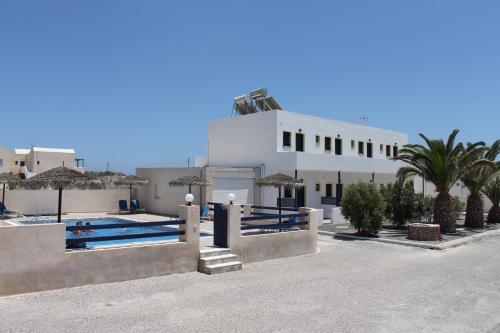 un edificio bianco con piscina e palme di Mary Rooms a Perivolos