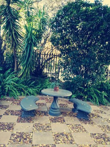 a table and two benches sitting on a patio at Belmont Guesthouse in Bloemfontein