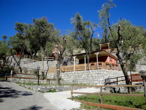 a house behind a stone wall with a fence at Tigullio Camping & Resort in Sestri Levante