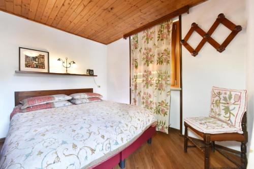 - une chambre avec un lit et une chaise dans l'établissement Residence Castelli, à Breuil-Cervinia