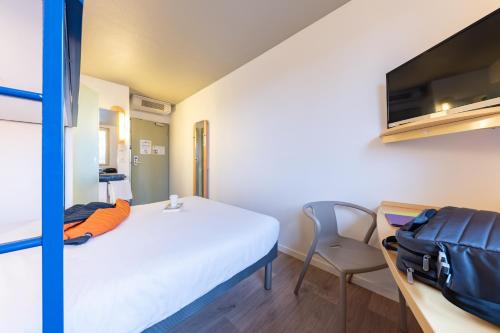 a hotel room with a bed and a desk at ibis budget Bourg en Bresse in Bourg-en-Bresse