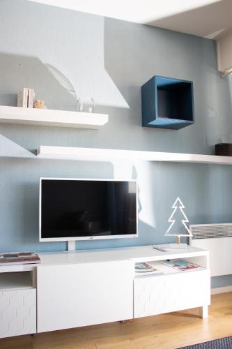 sala de estar con TV y estanterías blancas en Charmant séjour au coeur du Touquet en Le Touquet-Paris-Plage
