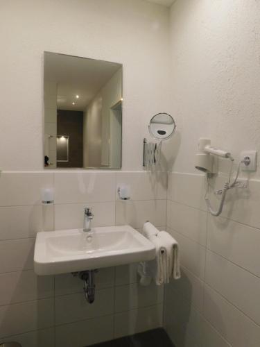 a bathroom with a sink and a mirror at Pension Haus Petra in Altenau