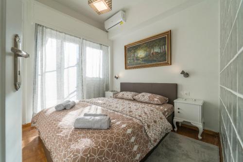 a bedroom with a bed and a large window at Piraeus_Faliro_Cosy apartment in Piraeus