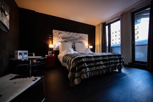 a hotel room with a bed and a large window at Avenue Lodge Hotel & Spa in Val dʼIsère