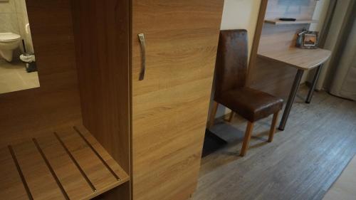 a wooden door with a chair next to a desk at Pension Turm in Schönwald