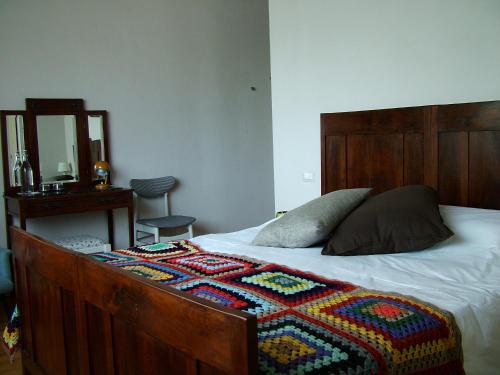 a bed with a wooden headboard and a blanket on it at Altrocanto in Farindola