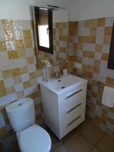 a bathroom with a toilet and a sink and a mirror at Casa Ombrieta in Beceite
