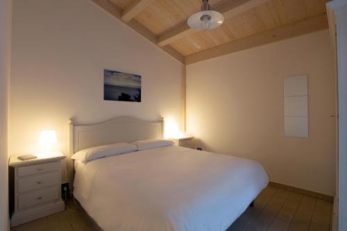 TorrenovaにあるAgricampeggio Alessandraのベッドルーム(白いベッド1台、ランプ2つ付)