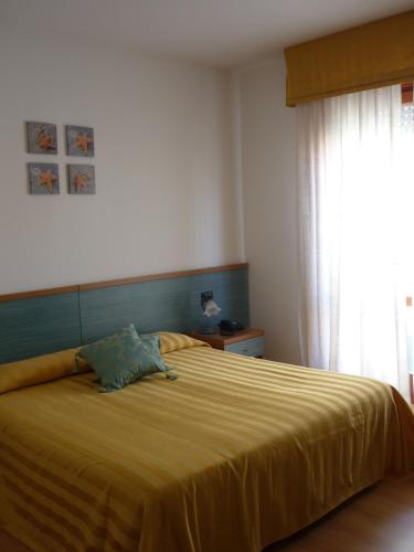 a bedroom with a large bed with a yellow blanket at Hotel Marea in Grado