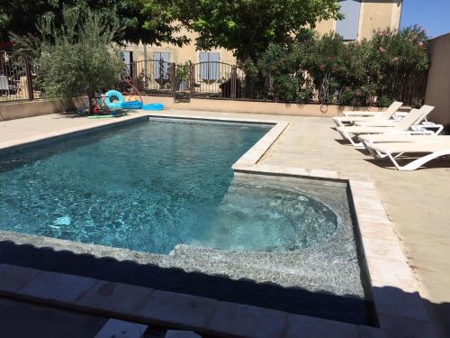 - une piscine avec des chaises longues dans l'établissement LA FERME, à Orange