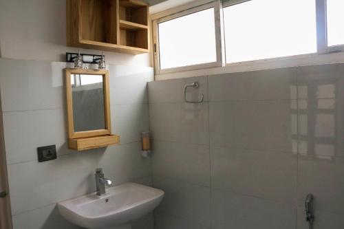 a bathroom with a sink and a mirror and a window at Chibha Classic Inn in Pātan