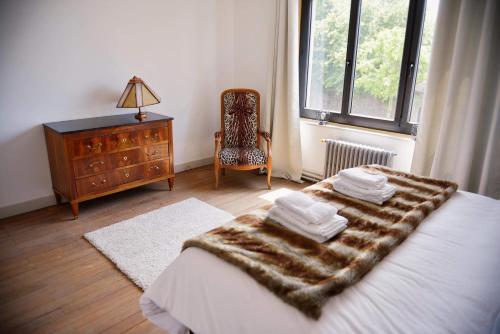 um quarto com uma cama, uma cómoda e uma janela em La Meunière em Saint-Martin-Boulogne