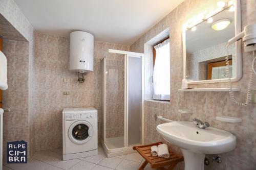 a bathroom with a sink and a washing machine at CASA MIFEL -- APP. GERANIO in Folgaria