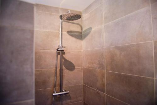 eine Dusche mit Duschkopf in einem Badezimmer in der Unterkunft La Meunière in Saint-Martin-Boulogne