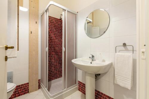 een badkamer met een wastafel, een douche en een spiegel bij Agricampeggio Alessandra in Torrenova