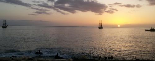 a sunset over the water with people on the beach at bed & breakfast Regina in Tarrafal