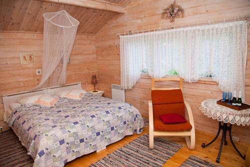 1 dormitorio con 1 cama, 1 mesa y 1 silla en Lepametsa Holiday Houses, en Nasva