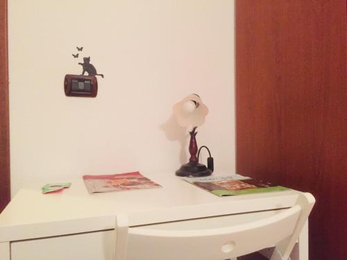 a white desk with a lamp and a clock on a wall at Agriturismo Pranu in Sorgono