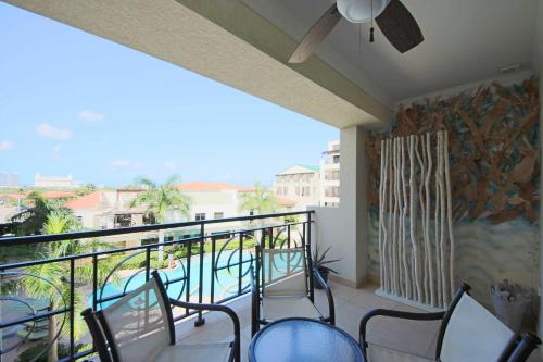 a balcony with chairs and a view of a pool at Aruba Stop by The Stop Club in Palm-Eagle Beach
