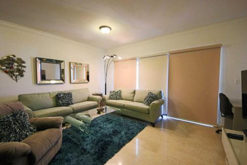 a living room with two couches and a sliding door at Aruba Stop by The Stop Club in Palm-Eagle Beach