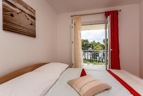a bedroom with two beds and a window at Mare & Mons Seafront Apartments in Malinska