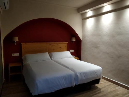 Beach Hotel Dos Mares في تريفة: غرفة نوم مع سرير أبيض كبير مع اللوح الأمامي الأحمر