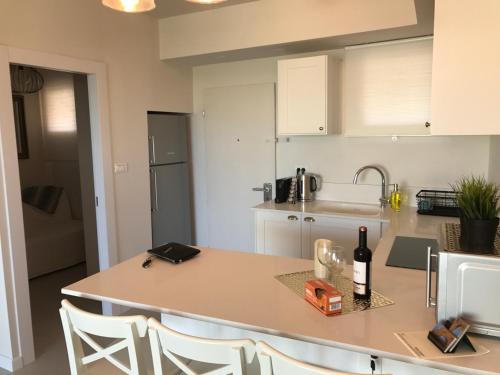 a kitchen with a table with a bottle of wine on it at Suite Caesar - Neot Golf in Caesarea