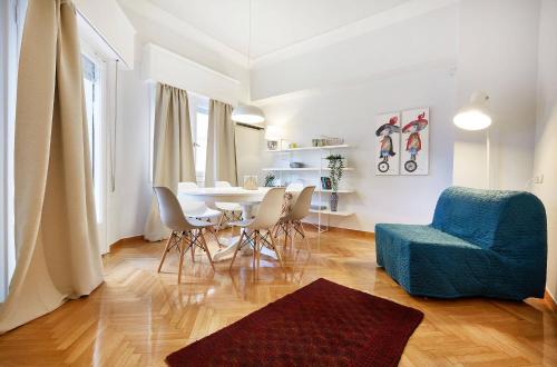 a living room with a blue chair and a table at Chloe Boutique Apartments Metropolis in Athens