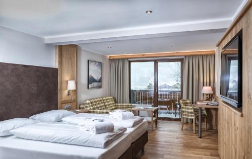 een hotelkamer met 2 bedden en een balkon bij Das Pfandler Hotel in Pertisau