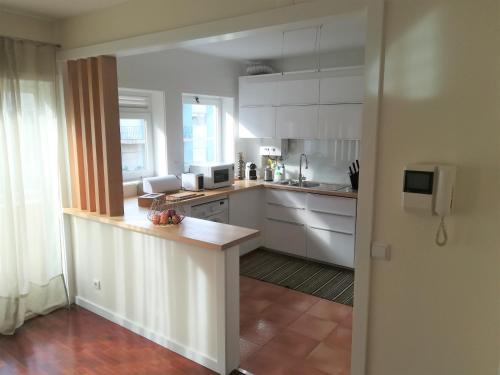 een keuken met witte kasten en een aanrecht bij Matosinhos Beach Apartment in Matosinhos