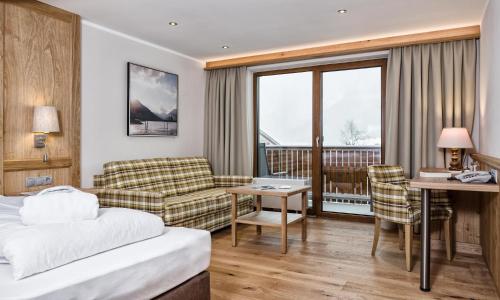 a hotel room with a bed and a desk at Das Pfandler in Pertisau