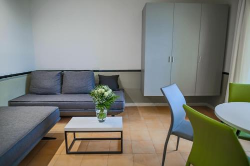 a living room with a couch and a table with a vase of flowers at Corfu Aqua Nisaki in Nisakion
