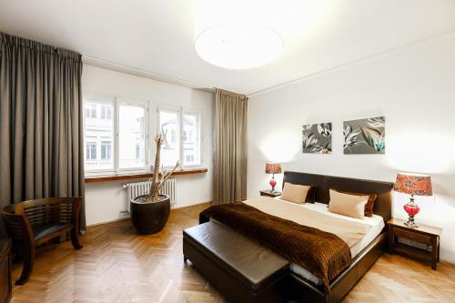 a bedroom with a large bed and a chair at LUXURY Apartment Dlouha in Prague