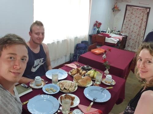 un grupo de personas sentadas alrededor de una mesa con comida en Surf reef guest house, en Mirissa
