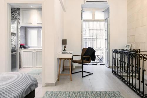 a bedroom with a desk and a bed with a chair at 88, Valletta Boutique Escape in Valletta