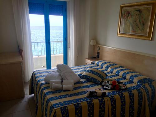 a hotel room with a bed with a view of the ocean at Sea Palace Hotel in Marina di Fuscaldo