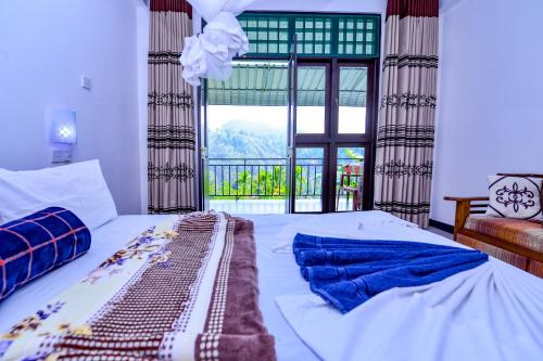 a bedroom with a bed and a large window at Dimuthu Home Stay in Ella