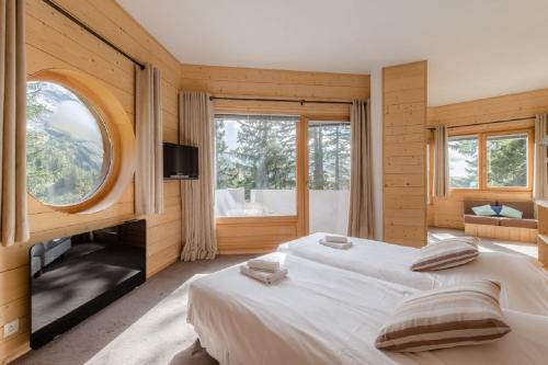 a bedroom with two beds and a large window at Chalet de Prestige l'Arketa - maeva Home - maeva Home in Avoriaz