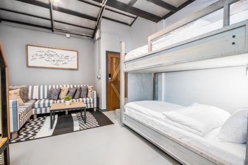 a bedroom with a bunk bed and a couch at Mimi and Jim Co-living space in Cha Am