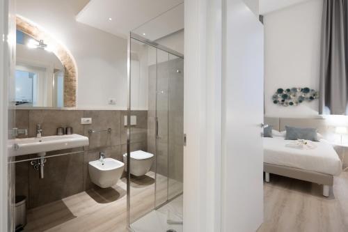 La salle de bains est pourvue d'une douche, d'un lavabo et d'un lit. dans l'établissement Duomo apartment, à Vérone