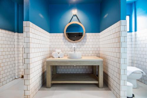 a bathroom with blue and white tiled walls and a sink at Mimi and Jim Co-living space in Cha Am