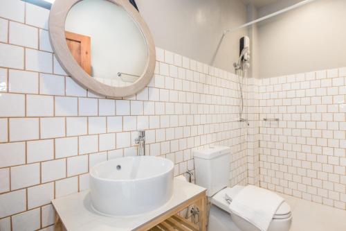 a bathroom with a sink and a mirror and a toilet at Mimi and Jim Co-living space in Cha Am