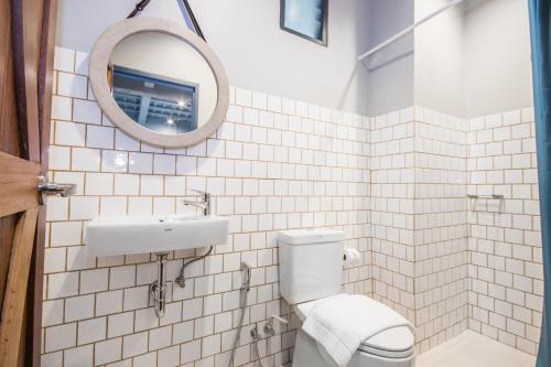a bathroom with a toilet and a sink and a mirror at Mimi and Jim Co-living space in Cha Am