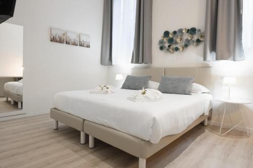 - une chambre blanche avec un grand lit et des draps blancs dans l'établissement Duomo apartment, à Vérone